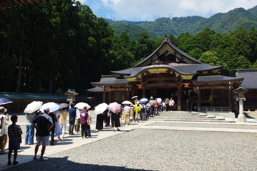 「弥彦神社の拝殿と参拝する人々」
